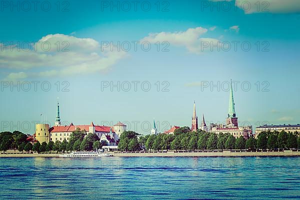 Vintage retro hipster style travel image of View of Riga over Daugava river: Riga Castle