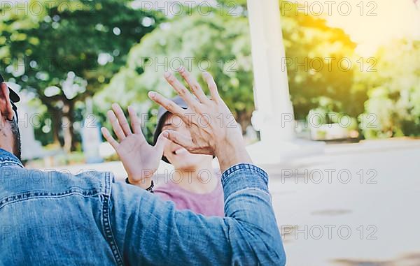 Close up of smiling people shaking hands in a park. Concept of two friends greeting each other with a handshake on the street