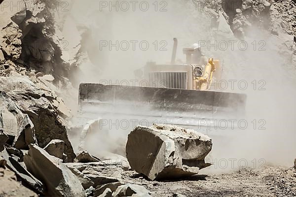 Bulldozer cleaning landslide from road in Himalayas. Himachal Pradesh