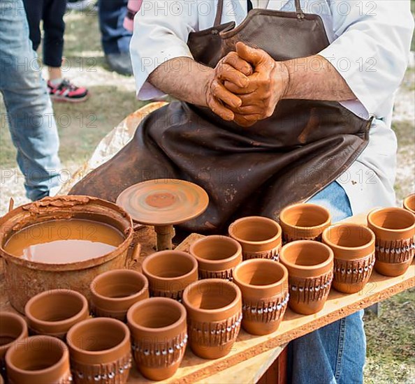 Potter hands shaping up the clay of the pot