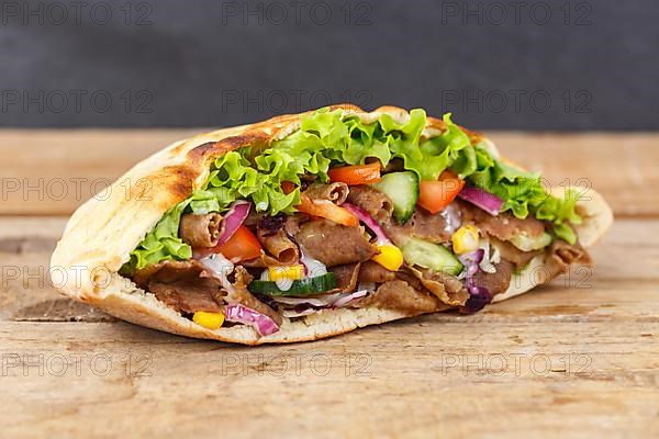 Doener Kebab Doner Kebap fast food meal in pita bread on wooden board in Stuttgart