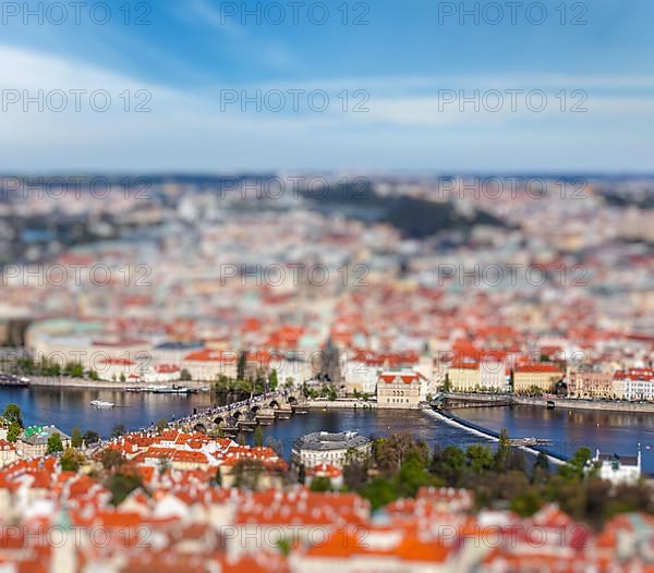 Aerial view of Charles Bridge over Vltava river and Old city from Petrin hill Observation Tower with tilt shift toy effect shallow depth of field. Prague