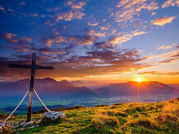 Summit cross of the Schlenken at sunset clouds