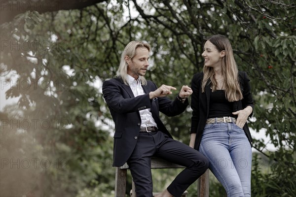 Man and woman talking on a wooden table in nature