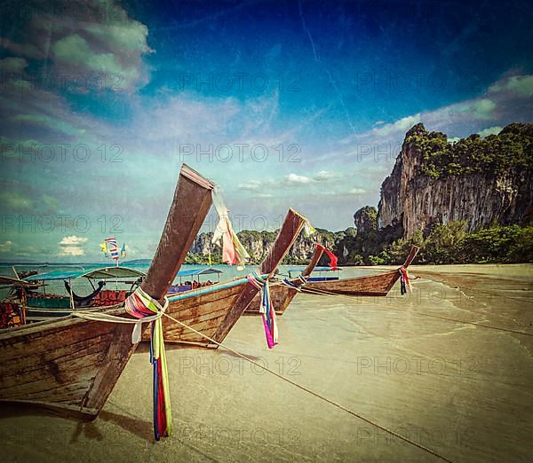 Vintage retro hipster style travel image of Long tail boats on tropical beach