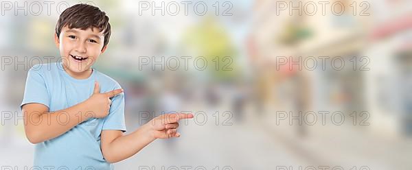 Child boy pointing finger at advertisement in the city with copy space Copyspace in Stuttgart