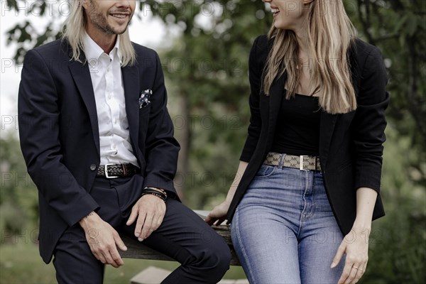 Man and woman talking on a wooden table in nature