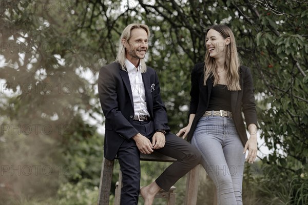 Man and woman talking on a wooden table in nature