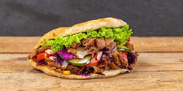 Doener Kebab Doner Kebap fast food in pita bread on wooden board Panorama in Stuttgart