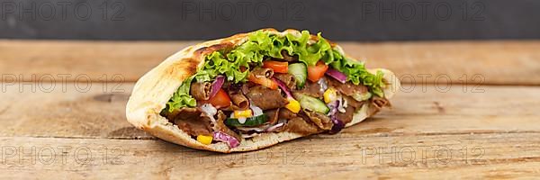 Doener Kebab Doner Kebap fast food food in pita bread on wooden board Panorama copy space Copyspace in Stuttgart