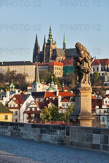 Statue on Charles Brigde with St. Vitus Cathedral in background in Prague