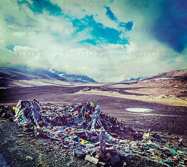 Vintage retro effect filtered hipster style travel image of Buddhist prayer flags lungta on Baralacha La pass on Manali-Leh highway in Himalayas. Himachal Pradesh