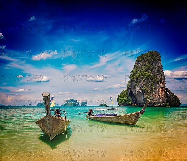 Vintage retro effect filtered hipster style travel image of long tail boats on tropical Pranang beach