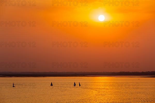 Yacht boats silhouettes in lake on sunset