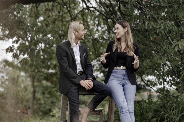 Man and woman talking on a wooden table in nature