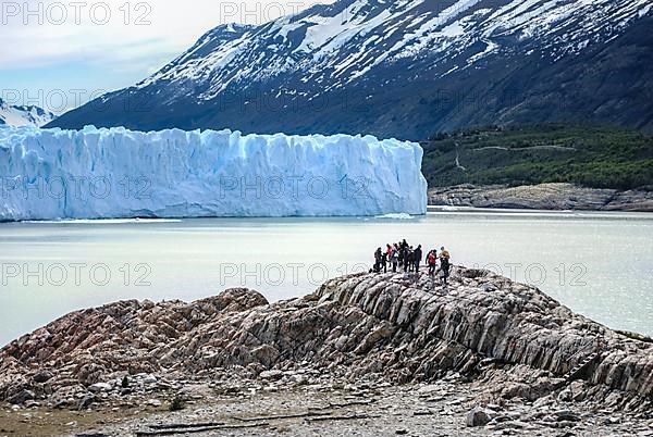 Travelers looking at Perito Moreno glacier located in Patagonia