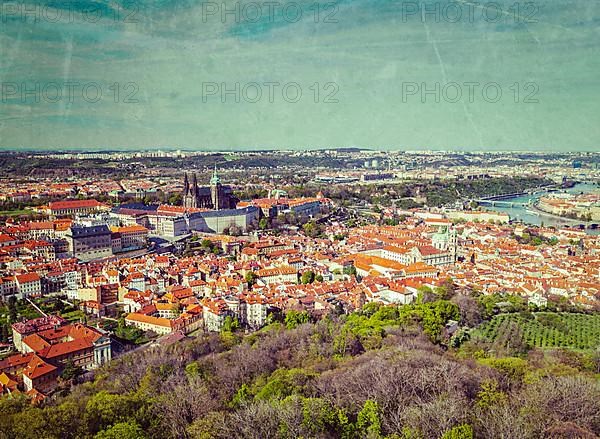 Vintage retro hipster style image of aerial view of Hradchany the Saint Vitus Cathedral and Prague Castle from Petrin Observation Tower with grunge texture overlaid. Prague