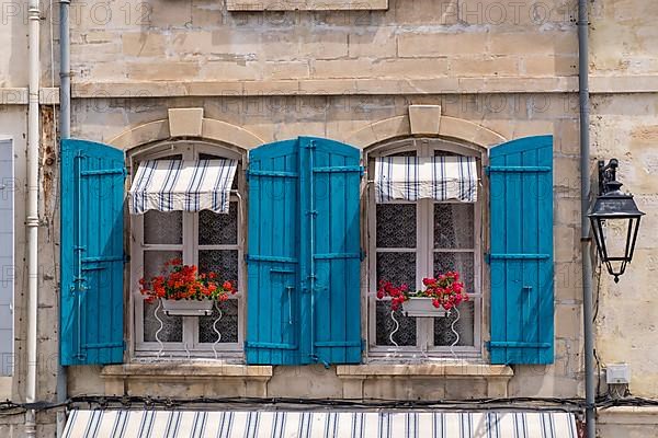 Window with blue shutters and red geraniums