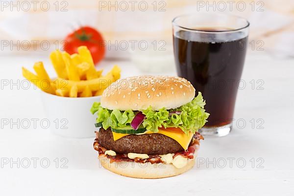 Hamburger cheeseburger fast food meal menu with fries and coke drink on wooden board in Stuttgart