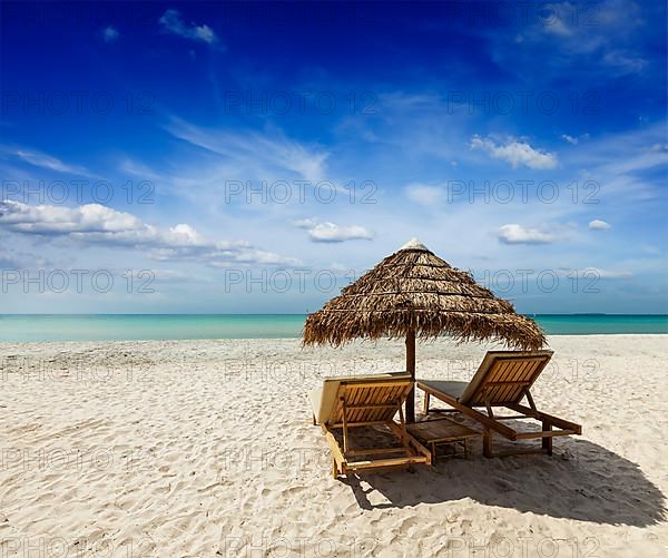 Two beach lounge chairs under tent on beach. Sihanoukville