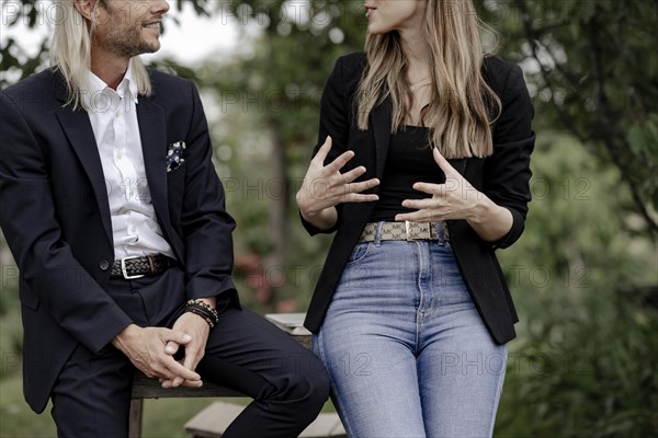 Man and woman talking on a wooden table in nature