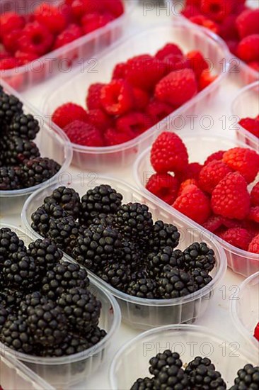 Fresh blackberries and raspberries at a market stall
