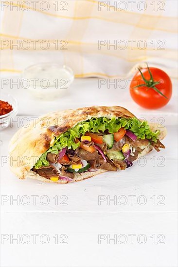 Doener Kebab Doner Kebap fast food meal in pita bread on wooden board in Stuttgart