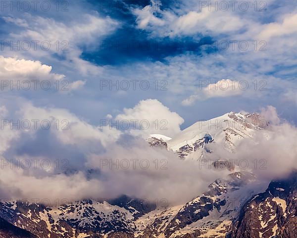 Snowcapped summit top of mountain in Himalayas in clouds. Himachal Pradesh