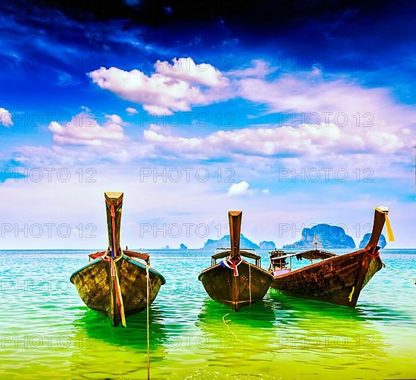 Vintage retro effect filtered hipster style travel image of long tail boats on tropical beach