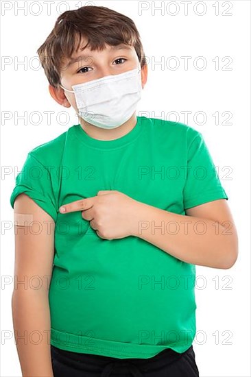 Child boy pointing finger at plaster during children vaccination mask against coronavirus corona virus isolated exempt in Stuttgart