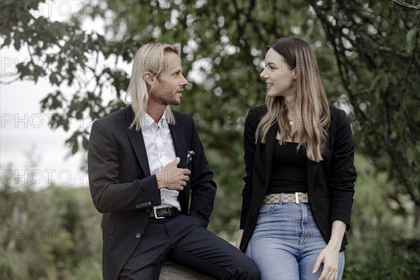 Man and woman talking on a wooden table in nature