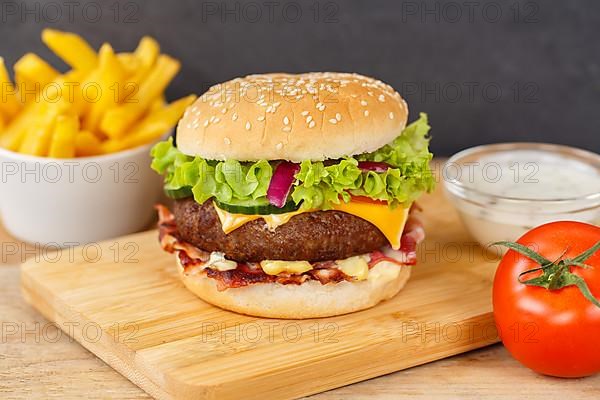 Hamburger cheeseburger fast food meal with fries on wooden board in Stuttgart