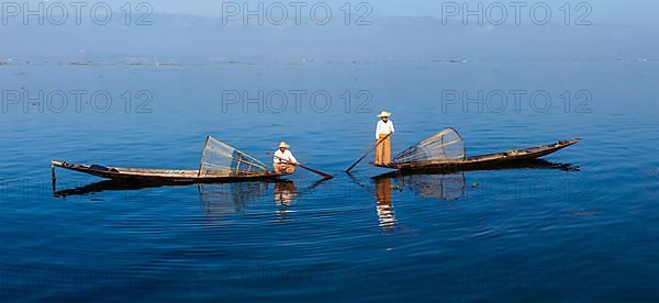 Panorama of traditional Burmese fishermen with fishing net at Inle lake in Myanmar famous for their distinctive one legged rowing style