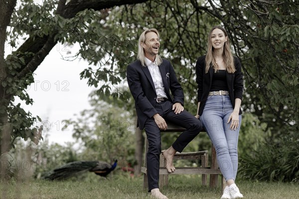 Man and woman talking on a wooden table in nature