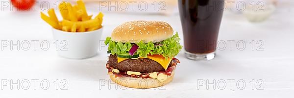 Hamburger cheeseburger fast food meal menu with fries and coke drink on wooden board Panorama in Stuttgart