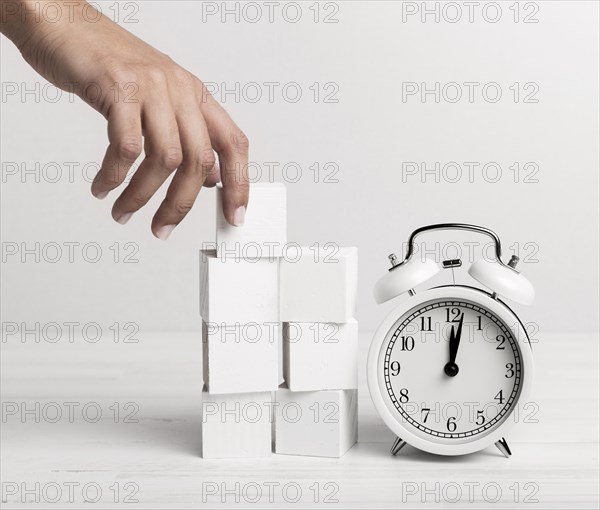 Hand putting white cubes clock