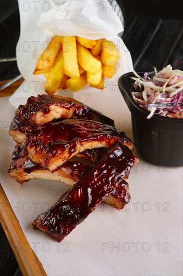 Grilled ribs served with fried potato and red cabbage