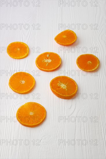 Orange slices on white rustic wooden background