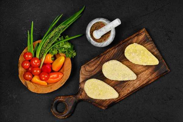 Top view of semifinished homemade zander cutlet on a wooden serving board