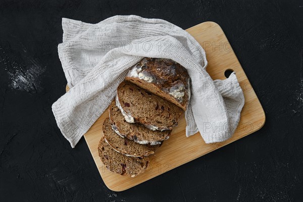 Overhead view of artisan freshly baked broun bread with raisins cut on slices