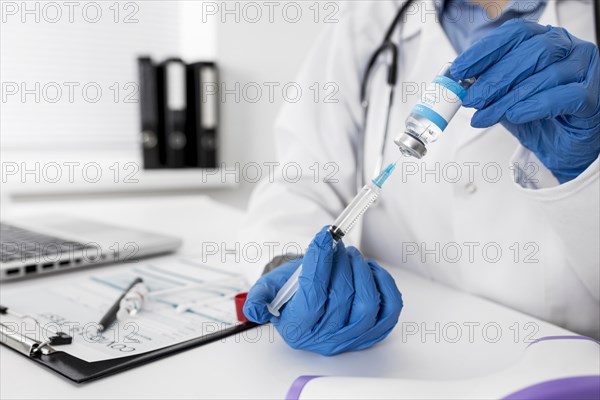 Close up doctor holding medical syringe