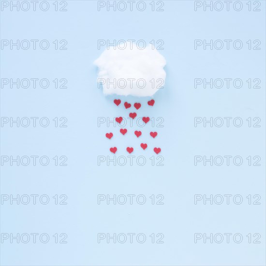 Red hearts falling from cloud
