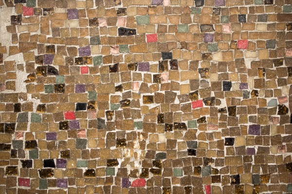 Concrete wall is covered with colorful mosaic