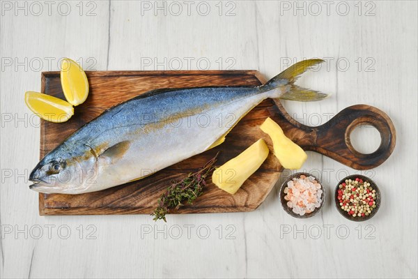 Top view of whole fresh chinook on wooden cutting board with spice