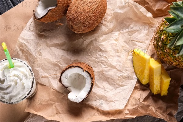 Top view of unfolded paper on the table with splitted coconut