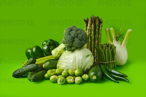 Various fresh green vegetables on wooden background