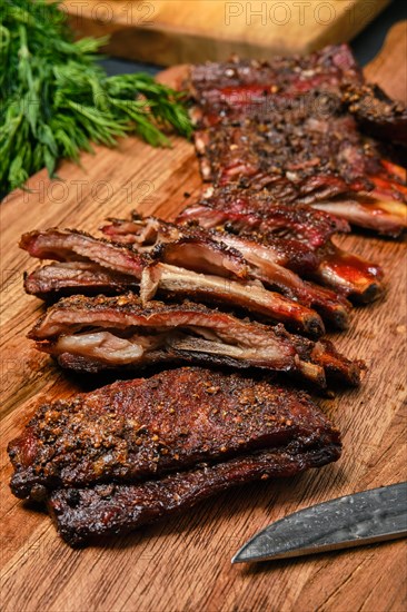 Top view of grilled lamb breast ribs on wooden cutting board