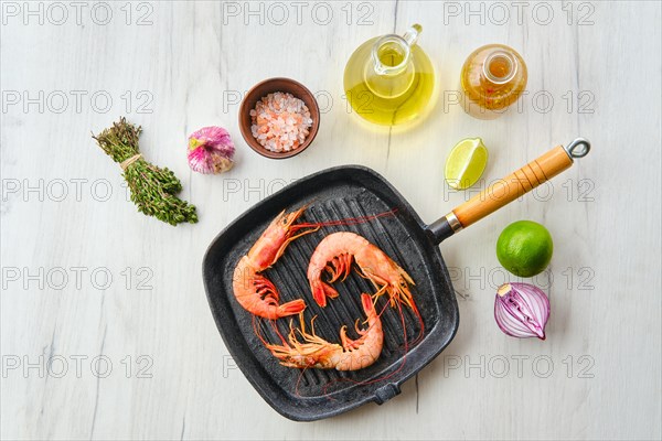 Top view of unpeeled shrimp with head in cast iron skillet