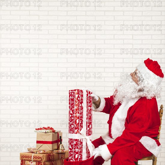 Santa claus putting presents bag