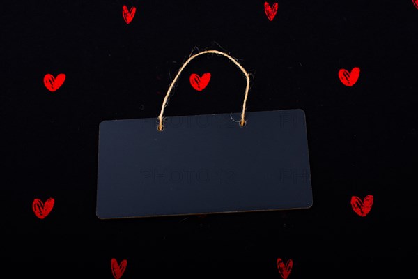 Rectangular shaped black notice board and red hearts on black background